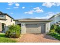 Single-Gathering home with a two-car garage, brick driveway, and well-maintained landscaping at 3005 Crispin Cir, Harmony, FL 34773