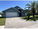Exterior front view of the home showing garage and front lawn on a sunny day at 3874 Blackberry Cir, St Cloud, FL 34769
