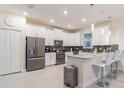 Modern kitchen with stainless steel appliances, white cabinetry and counter seating at 481 Ocean Course Ave, Davenport, FL 33896