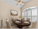 Dining room featuring a ceiling fan, plantation shutters on an arched window, and a wood table with set plates at 4811 Doc Dr, St Cloud, FL 34771