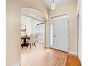 Bright foyer featuring hardwood floors, an arched entryway to the dining room, and a classic white front door at 4811 Doc Dr, St Cloud, FL 34771