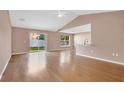 Bright living room with vaulted ceiling, hardwood floors, and sliding glass doors leading to the backyard at 50 Sawfish Ct, Kissimmee, FL 34759