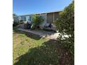 Exterior of home featuring siding, plants, and stone path, ideal for outdoor living at 50989 Highway 27 # 210, Davenport, FL 33897