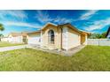Single-story home features a well-manicured lawn, attached garage, and beautiful curb appeal at 5275 Warrior Ln, Kissimmee, FL 34746