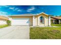 Charming single-story home features a well-manicured lawn, attached garage, and beautiful curb appeal at 5275 Warrior Ln, Kissimmee, FL 34746