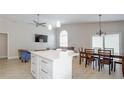 Bright open-plan living space with a kitchen island, dining area, and comfortable seating arrangement at 5275 Warrior Ln, Kissimmee, FL 34746