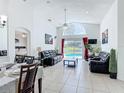 Bright living room featuring tile floors, vaulted ceilings, stylish furniture, and pool view at 529 Eagle Pointe N, Kissimmee, FL 34746