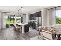 Open kitchen features modern appliances, a center island with seating, and views of the outdoor patio at 614 Heritage Square Dr, Haines City, FL 33844