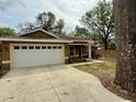 Charming single-story home featuring a two-car garage and well-manicured lawn at 74 N Oak Ave, Umatilla, FL 32784