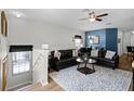 Comfortable living room featuring a ceiling fan, stylish area rug, and a cozy seating arrangement at 7526 Pellham Way, Kissimmee, FL 34747