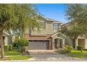 Charming two-story home with stone accents, a brick paver driveway and a two-car garage at 7615 Brookhurst Ln, Kissimmee, FL 34747