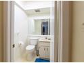 This bathroom offers a toilet, vanity, and a large mirror for a functional and well-lit space at 845 Orchid Springs Dr, Winter Haven, FL 33884