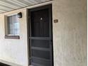 Exterior shot of front door, with stucco wall, security door and small window to the side at 845 Orchid Springs Dr, Winter Haven, FL 33884