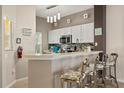 Eat-in kitchen featuring white cabinets, modern appliances, and stylish bar stool seating at 8534 Crystal Cove Loop, Kissimmee, FL 34747