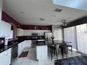 Modern kitchen with white cabinets, stainless steel appliances, and a large island at 8631 La Isla Dr, Kissimmee, FL 34747