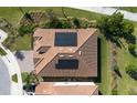 Aerial view of a roof with solar panels on a well-maintained, modern home with mature landscaping at 8999 Croquet Ct, Davenport, FL 33896