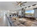 Spacious living room features modern design, large sectional, and open floorplan to kitchen at 9190 Sommerset Hills Dr, Davenport, FL 33896