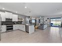 Open-concept living space boasts a stylish kitchen and comfortable living area with pool access at 9190 Sommerset Hills Dr, Davenport, FL 33896