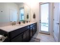 Bathroom showcasing double sinks, dark wood cabinets, and direct outdoor access at 1025 Leader St, Davenport, FL 33896