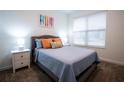 Well-lit bedroom featuring a queen-sized bed with a padded headboard and bright accent pillows at 1025 Leader St, Davenport, FL 33896