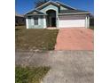 Exterior shot of the house with a 2-car garage and front yard at 1149 E Grove Ave, Lake Wales, FL 33853