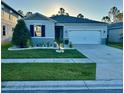 Charming single-story home with lush front lawn and an attached two-car garage at 1153 Augustus Dr, Davenport, FL 33896