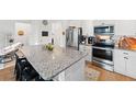 Modern kitchen with stainless steel appliances, granite countertops, and a large center island with seating at 1153 Augustus Dr, Davenport, FL 33896