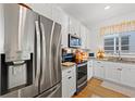 Well-equipped kitchen features stainless steel appliances, granite countertops, and white cabinetry at 1153 Augustus Dr, Davenport, FL 33896