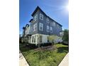 View of the modern townhome showcasing the well-maintained lawn and contemporary architectural design at 12673 Yoshino Aly, Orlando, FL 32827