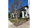 Townhome showcases a covered porch, glass-railed balcony, and a professionally landscaped front yard at 14129 Walcott Ave, Orlando, FL 32827