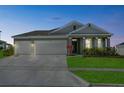 Charming single Gathering home with a well manicured lawn and 2-car garage at dusk at 14419 Topaghan Way, Winter Garden, FL 34787