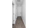 Hallway featuring white walls, light wood-look flooring and two doors on the left at 1449 Monte Carlo Trl, Orlando, FL 32805