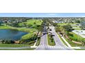 Community aerial view showcasing lush green golf course, a serene lake, and beautiful homes at 213 Strathmore Cir, Kissimmee, FL 34744