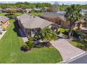 Charming single-story home with lush lawn, mature landscaping, and brick paver driveway offers great curb appeal at 238 Acadia Dr, Poinciana, FL 34759