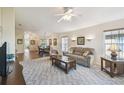 Bright and airy living room features a ceiling fan, neutral color palette, and views into the dining area at 238 Acadia Dr, Poinciana, FL 34759