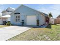 A well-maintained single-story home featuring a concrete driveway and small bushes at 2432 Olive Branch Way, Orlando, FL 32817