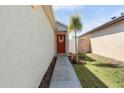 Inviting red front door with seasonal decor and a well-kept walkway at 2432 Olive Branch Way, Orlando, FL 32817