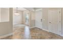 Open-concept foyer with tile flooring, neutral walls, and decorative chandelier at 30439 Gidran Ter, Mount Dora, FL 32757