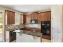 Kitchen with dark wood cabinets, granite countertops, and stainless steel appliances at 30439 Gidran Ter, Mount Dora, FL 32757