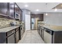 Modern kitchen with stainless steel appliances, granite countertops, and dark wood cabinets at 3131 Bass Boat Way, Kissimmee, FL 34746