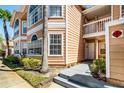 Condo exterior featuring well-maintained landscaping, a palm tree, and light-colored siding at 3161 Britannia Blvd # A, Kissimmee, FL 34747