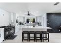 Bright kitchen boasts white cabinets, a center island, and a contrasting black accent wall at 3263 Lorimar Ln, St Cloud, FL 34772