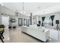 Spacious living room with neutral tones, white leather furniture, and tile flooring at 3263 Lorimar Ln, St Cloud, FL 34772