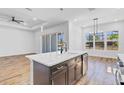 Contemporary kitchen island featuring a stainless steel dishwasher, a sink, and wood flooring at 362 Villa Sorrento Cir, Haines City, FL 33844