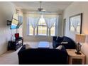 Cozy living room with large window, comfortable seating, a ceiling fan, and a wall-mounted TV at 366 Jaybee Ave, Davenport, FL 33897