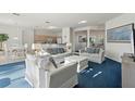 Bright living room featuring white sofas with blue accents and plush blue carpet at 376 Belfry Dr, Davenport, FL 33897