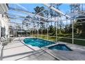 Enclosed pool and hot tub with an outdoor seating area and backyard view at 376 Belfry Dr, Davenport, FL 33897