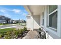 Inviting covered front porch with a cozy seating area, complemented by lush landscaping at 4623 Wandsworth Way, Davenport, FL 33837