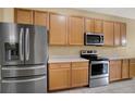 Efficient kitchen featuring stainless steel appliances, light wood cabinetry, and neutral countertops at 4900 Marbella Isle Dr, Orlando, FL 32837