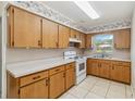 Functional kitchen featuring wooden cabinets, laminate countertops, and updated white appliances at 612 California Ave, St Cloud, FL 34769